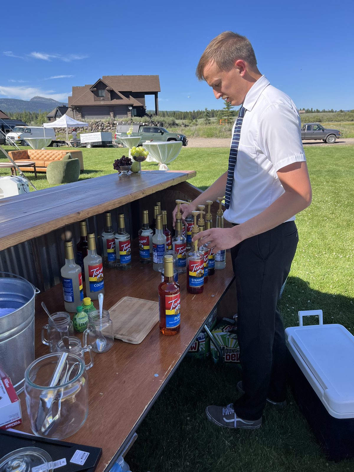 Bartender arranging syrup pumps at an outdoor event
